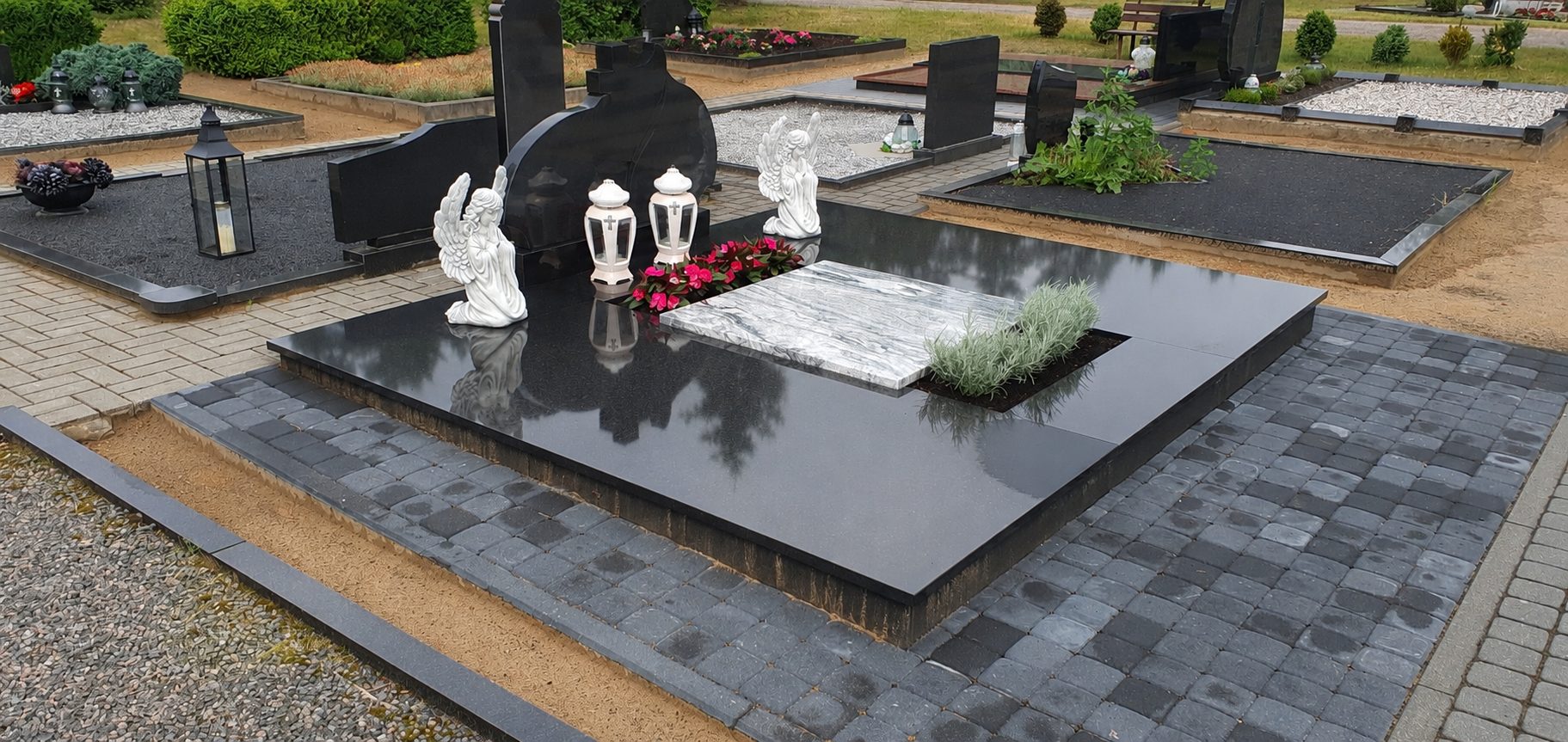 Juodo poliruoto granito kapavietė su angelų skulptūromis